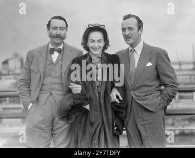 DER ALTE PAL hat offenbar überlegt, ob Freundschaft so weit gehen sollte, wie der britische Filmschauspieler David Niven zusieht, wie sein Freund Michael Trubshawe einen Willkommenskuss auf die Wange von Mrs. Niven pflanzt. Die Nivens waren gerade aus Amerika in Southampton angekommen, der Cunard-Linienschiff Queen Mary. Die beiden Männer sind Freunde, seit sie 1929 in der Highland Light Infanterie gedient haben. Mr. Trubshawe - manchmal um in David Niven Filmen zu sehen - war der beste Mann auf der Hochzeit des Schauspielers, ist Pate der Niven Kinder und grüßt die Nivens immer bei ihrer Rückkehr nach England. 9. März 1 Stockfoto