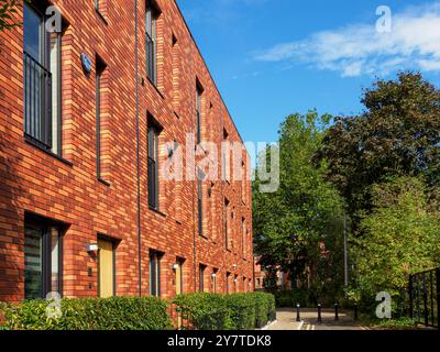 Salford, Manchester, Großbritannien. 28. September 2024: Modernes Backsteingebäude in ruhiger Nachbarschaft an einem sonnigen Tag. Stockfoto