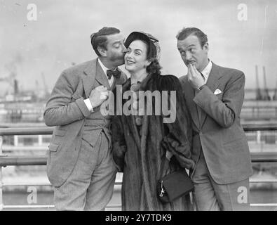 DER ALTE PAL hat offenbar überlegt, ob Freundschaft so weit gehen sollte, wie der britische Filmschauspieler David Niven zusieht, wie sein Freund Michael Trubshawe einen Willkommenskuss auf die Wange von Mrs. Niven pflanzt. Die Nivens waren gerade aus Amerika in Southampton angekommen, der Cunard-Linienschiff Queen Mary. Die beiden Männer sind Freunde, seit sie 1929 in der Highland Light Infanterie gedient haben. Mr. Trubshawe - manchmal um in David Niven Filmen zu sehen - war der beste Mann auf der Hochzeit des Schauspielers, ist Pate der Niven Kinder und grüßt die Nivens immer bei ihrer Rückkehr nach England. 9. März 1 Stockfoto