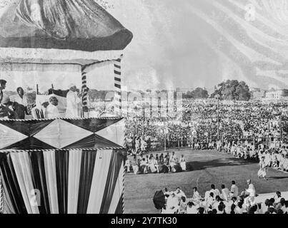 Pandit Nehru entkommt nur knapp dem Attentat Kalkutta , Indien : Pandit Jawarharlal Nehru , der Premierminister von Indien, entkam knapp dem Attentat auf einem Massentreffen auf dem Calcutta Maidan. Als er das Rostrum aufnahm, wurde eine Bombe 100 Meter entfernt an einem Punkt geworfen, an dem das Auto einen Moment zuvor vorbeigefahren war. Ein Polizist wurde getötet und fünf verletzt. Zwei Männer wurden verhaftet. Nachdem Herr Nehru den Maidan verlassen hatte, wurden zwei nicht explodierte Bomben in der Nähe des Rostrums gefunden. Foto zeigt: Pandit Nehru spricht vom Pult. In ihm sitzt der amtierende Premierminister von Westbengalen, Mr. N R Sarkar (Nahkamera) und Stockfoto