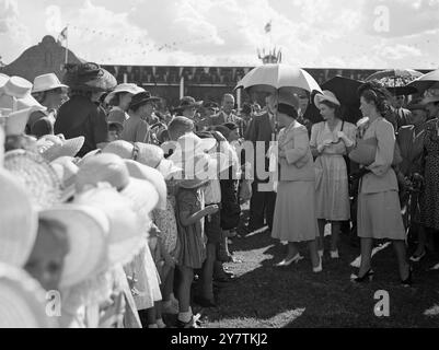 Royal Tour of South AfricaPHoto zeigt: Königin Elizabeth lächelt unter ihrem Sonnenschirm in Anerkennung der Begrüßung der Kinder in Standerton , Transvaal , während der Tour der Royal Family durch Südafrika . Zu den Kindern, die so offensichtlich froh sind, die Königin zu sehen, gehören 12 Indianer, die von ganzem Herzen an der loyalen Demonstration gegenüber der Königlichen Familie teilgenommen haben, obwohl die indische Gemeinschaft in Südafrika am 31. März 1947 Differenzen mit der südafrikanischen Regierung hat Stockfoto