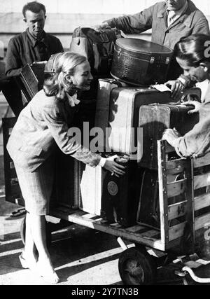 Filmstar bewegt ihr eigenes Gepäck Michele Morgan , der französische Filmstar, der nach Frankreich zurückgekehrt ist, um an den Filmfestspielen in Cannes teilzunehmen, musste bei der Ankunft am Flughafen Orly, Paris, wo die Träger streikten, ihr eigenes Gepäck mitnehmen. Fotoshows: Michele Morgan leiht sich am 26. September 1946 am Flughafen Orly, Paris, mit einem Lastwagen-Gepäck zur Hand Stockfoto