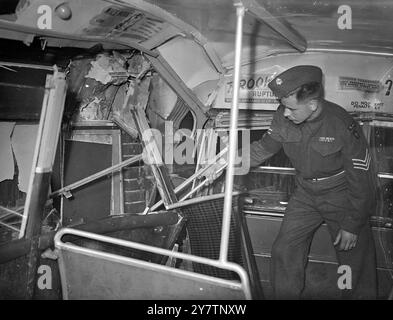 LONDONER STURM ENTWURZELT STRASSENSPERREN - VERURSACHT BUSSTÜRZE IN DEN LADEN - 13 MENSCHEN VERLETZT. Der schreckliche Sturm über London führte dazu, dass Straßensperren in der Kensington High Street entwurzelt wurden. Ein Bus von 49 rutschte auf den entwurzelten Straßenblöcken und stürzte in ein Schaufenster. 13 Menschen wurden verletzt und mit 3 schwer ins Krankenhaus gebracht. Fotoshows: Sergeant J C Meldrum RASC aus Ilford, der einen Krankenwagen der Armee rief und half, die Verletzten aus dem Bus zu holen, sah man, wie er den Damm auf dem Oberdeck des abgestürzten Busses untersucht. 26. Juli 1946 Stockfoto