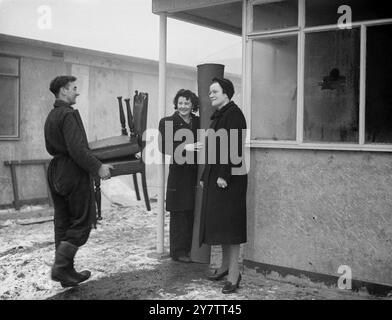 Das erste Fertighaus von Sandys wurde von Mrs. Mary Dyett, ihrem Ehemann und ihrer 17-jährigen Tochter Eileen bewohnt, seit Mr. Duncan Sandys Lord Portall übernahm. Bis sie in ihr neues Haus zogen , das eine von sechs vorgefertigten Wohnungen auf einem Bombengelände in der Thames Street, Greenwich, Südost-London ist, hatte die Familie Dyett, die aus ihrem eigenen Haus bombardiert wurde, in öffentlichen Notunterkünften geschlafen. George Dyett trägt Möbel in das vorgefertigte Haus. Mrs. Dyett und ihre Tochter Eileen stehen vor der Tür Stockfoto