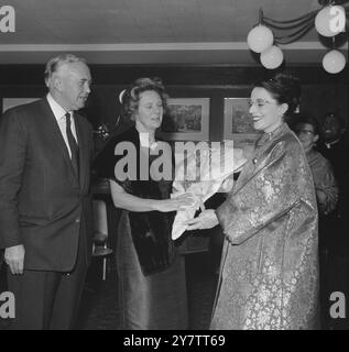 491213 PREMIERS FRAU SETZT BLUMEN AUF SILBERFEIER. LONDON: ALS DER BRITISCHE PREMIER, HAROLD WILSON, SEINE FRAU MARY (MITTE), HEUTE ABEND AM SILBERNEN JUBILÄUMSDINNER DER COMMONWEALTH KORRESPONDENTEN' ASSOCIATION IM HILTON HOTEL IN LONDON TEILNAHM, ERHIELT LETZTERES BEI DER ANKUNFT EINEN BLUMENSTRAUSS VON MRS. SYED, DER FRAU DES PRÄSIDENTEN DER VEREINIGUNG. VOR WENIGER ALS EINER WOCHE VERANSTALTETEN MR. UND MRS. WILSON IHREN EIGENEN SILBERNEN ANLASS - IHRE SILBERNE HOCHZEIT ...-FEIER - BEI IHREM WEIHNACHTSFEIERLICHEN URLAUB AUF DEN SCILLY ISLES. 7. JANUAR 1965 Stockfoto