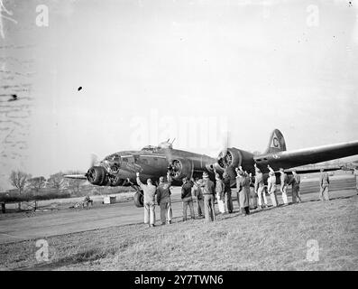 „KNOCK OUT DROPPER“ HÄLT DIE FÜHRUNG BEIM BOMBARDEMENT-MARATHON der FLIEGENDEN FESTUNG Foto zeigt: Während die Flying Fortress „ Knock Out Droppe r“ auf die Start- und Landebahn fährt, gibt ihre Bodencrew, die sie für 49 operative Missionen im Fliegen gehalten hat, der Crew einen aufregenden Abflug. 13. November 1943 Stockfoto