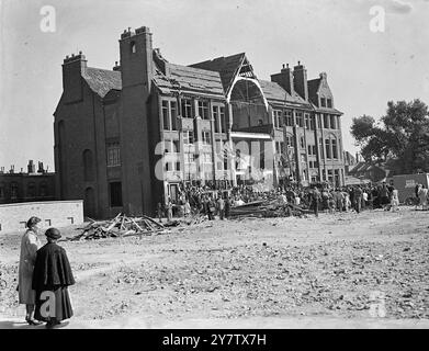 EAST LONDON FEIERT DEN ZWEITEN JAHRESTAG DER SCHLACHT UM GROSSBRITANNIEN anlässlich des zweiten Jahrestages der Schlacht um Großbritannien besuchte das Volk von Stepney, einem sehr stark verwüsteten Gebiet im East End von London, einen Gottesdienst ihres Rektors, Reverend Reginald French, in den Ruinen einer verheerten Schule im Distrikt, um dem Mut der RAF-Männer zu gedenken, die London in der Schlacht um Großbritannien verteidigten. Foto zeigt: Eine allgemeine Ansicht des laufenden Dienstes vor der geschädigten Schule in Stepney. 15. September 1942 Stockfoto