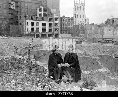 AMERIKANISCHE KRANKENSCHWESTERN SEHEN BOMBE BESCHÄDIGTE STADT Foto zeigt: Zwei amerikanische Krankenschwestern aus Kansas City, USA, heute in London, besuchten einige der bombardierten Gebiete der City of London. Hier werden sie zwischen den Trümmern von bombardierten Gebäuden sitzen gesehen, wo auch Blumen wachsen. Sie sind Second Lieutenant Marion Cross (links) und Second Lieutenant Dorothy Downs. 18. September 1942 Stockfoto