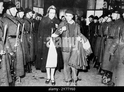 VERWUNDETE FRANZÖSISCHE SOLDATEN KOMMEN NACH VICHY Foto zeigt: Verwundete französische Soldaten, unterstützt von Krankenschwestern des Roten Kreuzes, die zu den ersten Zugladungen verletzter französischer Soldaten gehörten, die aus besetzten Gebieten nach Vichy kamen und an einer Ehrenwache vorbeigingen. 18. Dezember 1940 Stockfoto