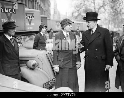 Lord Woolton nahm heute einen großen Teil der ersten Flotte von 100 mobilen Kantinen auf, die von Bertram de N. Cruger, dem Vertreter des amerikanischen Alliierten Hilfsfonds in Großbritannien, vorgestellt wurde. Lord Woolton (rechts) inspiziert einige der Kantinen mit einem Mitglied der YMCA Woman's Auxiliary. 19. Dezember 1940 Stockfoto