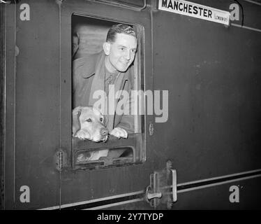 Ein GUNNER's MASKOTTCHEN Foto zeigt: AA Gunner John Gordon mit seinem Hund „Reb“ an einer Londoner Station vor ihrer Abreise. Sein Haustier ist seit Beginn des Krieges bei ihm und ist immer bei ihm, egal ob er seine Waffen abfeuert oder abfeuert, und er ist gleichgültig gegenüber dem Brüllen seiner Meister AA-Geschütze. 4. Februar 1941 Stockfoto