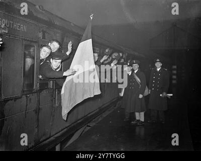 BELGISCHE SEELEUTE, DIE IHRE NATIONALFLAGGE TRAGEN - VERLASSEN SIE den BAHNHOF LONDON Foto zeigt: Diese Belgier, von denen die meisten Fischer sind, die jetzt bei der Royal Navy (der Belgischen Division) dienen, winken fröhlich aus einem Zug, während ihre Flagge im Wind flattert, als sie einen Bahnhof in London verlassen. Wenn sie auf eines der Schiffe seiner Majestät geschickt werden, nehmen sie ihre Flagge am 1. Februar 1941 mit Stockfoto