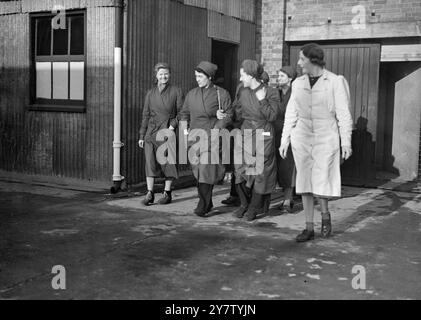 HAUSFRAUEN BILDEN SICH ZU INGENIEUREN AUS IN DER STAATLICHEN AUSBILDUNGSSTÄTTE Housewives werden zu erfahrenen Ingenieuren ausgebildet. Sie lernen Flugzeugbau, Radialbohren und Formen neben vielen anderen wesentlichen Anforderungen für die Kriegsanstrengungen. Auf diese Weise werden viele Männer für die Kampftruppen freigelassen, Foto zeigt: Einige der Auszubildenden verlassen ihre Arbeit, nachdem sie ihre „Schicht“ am 26. Januar 1941 erledigt haben Stockfoto