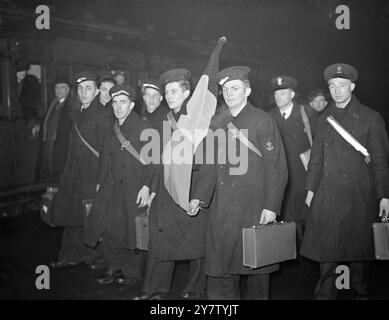 BELGISCHE SEELEUTE MIT IHRER NATIONALFLAGGE VERLASSEN DEN LONDONER BAHNHOF. Foto zeigt: Diese Belgier, von denen die meisten Fischer sind und jetzt in der Royal Navy (der Belgischen Division) dienen, marschieren durch eine Londoner Station, die stolz ihre Nationalflagge trägt, während sie sich auf den Weg vorbereiten. Wenn sie auf einem Schiff seiner Majestät stationiert sind, nehmen sie ihre Flagge mit. 1. Februar 1941 Stockfoto