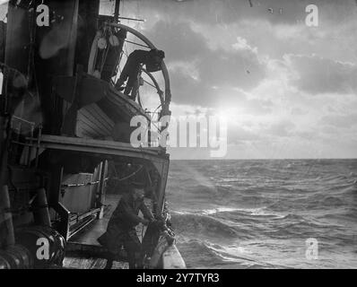 WINTERKONVOI diese Bilder wurden an Bord eines Begleitschiffs aufgenommen, das einen Konvoi begleitete, der Lebensmittel aus der Außenwelt und Vorräte von Hafen zu Hafen durch Wintermeere brachte, die durch Minen und U-Boote gefährlich wurden. Das Wetter war schlecht. Das Spray fror auf den Kleidern und Gesichtern der Schützen und Männer, die Wache hielten. Schwere Meere schlagen gegen diese kleinen Schiffe. Sie brachten ihre Fracht rein. Foto zeigt: Ein Sonnenuntergang auf dem turbulenten Wasser. 23. Dezember 1940 Stockfoto