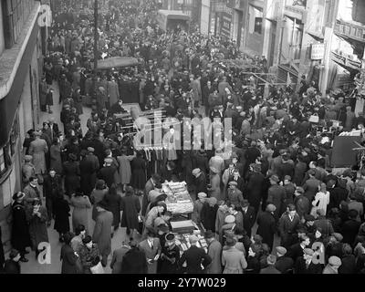 PETTICOAT LANE GEHT WEITER -- mit dem Annäherungsflug des berühmten Sunday Market in Petticoat Lane, Middlesex Street, ist East London in vollem Gange. - Foto zeigt: Die dichte Menge in der Petticoat Lane sucht Weihnachtsverhandlungen unter den vielen Straßenhändlern. - 8. Dezember 1940 Stockfoto