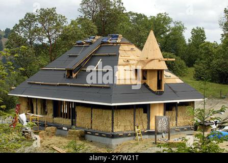 Cazadero, Kalifornien - Strohballen werden für den Bau eines ansonsten traditionellen Cotswald Cottages verwendet, das in den Hügeln des Sonoma County hinaufgeht. Das Haus mit zwei Schlafzimmern und zwei Badezimmern, das für James Yates aus San Francisco gebaut wird, verfügt über Reistrohballen, die auf der Außenseite des Hauses gestapelt und dann mit einer dicken Schicht Gipskement beschichtet sind. Häuser mit Strohballen-Komponenten werden immer beliebter bei Menschen, die nach erschwinglichem Wohnraum und Luxus suchen. Foto am Sonntag, 28. April 2002. Stockfoto