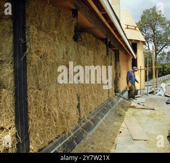 Cazadero, Kalifornien --James Yates aus San Francisco, Kalifornien, spaziert am Sonntag, 28. April 2002, vor seinem traditionellen Cotswald Cottage aus Strohballen. Strohballen werden für den Bau eines ansonsten traditionellen Cotswaldhauses verwendet, das in den Hügeln des Sonoma County hinaufgeht. Das Haus mit zwei Schlafzimmern und zwei Badezimmern, das für James Yates gebaut wird, verfügt über Reistrohballen, die auf der Außenseite des Hauses gestapelt und dann mit einer dicken Schicht Gipskement beschichtet sind. Häuser mit Strohballen-Komponenten werden immer beliebter bei Menschen, die nach erschwinglichem Wohnraum und Luxus suchen Stockfoto