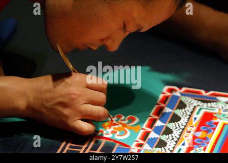 Stanford, Kalifornien - Ein tibetischer Bubismus des Drepung Gomang Monastery of India arbeitet am 14. Juni 2002 am Gerald Cantor Center for Visual Arts an der Stanford University. Sandmalerei ist eine antike Kunstform des tibertischen Buddhismus. Wenn die Mönche fertig mit dem farbigen Sand gemalt sind, werden sie ihn fegen und in einen Fluss oder Bach gießen, wo das Wasser heilende Energien durch die Welt trägt. Stockfoto