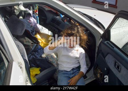 San Jose, Kalifornien: Desiree Jones, 6, sitzt auf dem Vordersitz der Familie Honda Civic auf dem Parkplatz der ersten christlichen Kirche in der Innenstadt von San Jose. Frau Jones und ihre Mutter Cindy Jordon und ihr Bruder Devon Jones leben in einem Obdachlosenheim im Gemeindehaus. Frau Jordon ist obdachlose Mutter mit vier Kindern und arbeitet als Verwaltungsassistentin für ein Hightech-Unternehmen im Silicon Valley. 02/19/01 Stockfoto