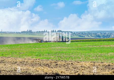Der Traktor pflügt im Sommer das Feld auf dem Land. Pflügerfeld für landwirtschaftliche Traktoren. Arbeitet im Feld Stockfoto