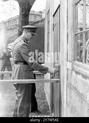 DUKE OF GLOUCESTER ERÖFFNET AUSSTELLUNG „PRISON OF WAR“ Fotoshows: Nach der Eröffnung der Ausstellung „Prison of war“, die aus einem Stalag-Modell besteht, mit uniformierten „deutschen“ Wachen, öffnet der Duke of Gloucester die Tür einer der Hütten. Der Erlös aus der Ausstellung, die im Londoner Clarence House durch Erlaubnis des Königs stattfindet, geht an den Fonds für Kriegsgefangene des Roten Kreuzes. 1. Mai 1944 Stockfoto