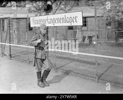 DEUTSCHER STALAG IM HERZEN LONDONS Ein realistischer Stalag oder Kriegsgefangenenlager in Deutschland wurde nun in den Gärten des Londoner Clarence House errichtet. Sie ist Teil der Prisons of war Exhibition, die im Auftrag des britischen Roten Kreuzes und des St. John Fund am 1. Mai eröffnet wird. Foto zeigt: Die „deutsche“ Wache patrouilliert den Stacheldraht des „Stalag“ in den Gärten des Clarence House, London. 30. April 1944 Stockfoto