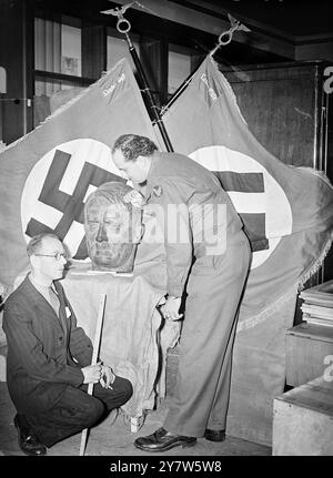 DEUTSCHE BOTSCHAFTSEINRICHTUNG ZUR AUKTION VORBEREITET: RIBBENTROP PLANT "NACH DEM SIEG". Der gesamte verbliebene Inhalt der ehemaligen deutschen Botschaft in Carlton House Terrace wurde nun in Earl'sCourt verlegt und wird von den Herren Knight Frank und Rutley zur Auktion katalogisiert. Es gibt einige seltsame Hinweise auf Ribbentrops Pläne, als er die Botschaft als deutscher Botschafter besetzte. Ein Funksender wurde in einem Penthouse auf dem Dach der Botschaft gefunden, und in einem Schreibtisch wurde eine Reihe von Karten gefunden, die die Namen aller britischen Kriegsschiffe und ihre Bewegungen im Jahr 1937 auflisten. Porträts von Hitler an Stockfoto