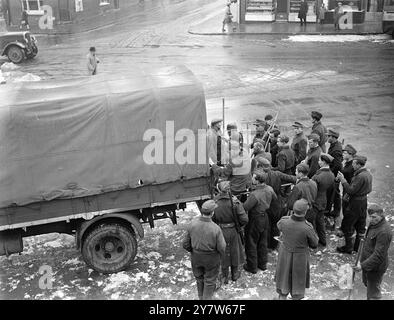 DEUTSCHE KRIEGSGEFANGENE RÄUMEN SCHNEE VON STRASSEN IN SÜDENGLAND. Parteien deutscher Kriegsgefangener räumen Schnee von Straßen in Südengland. Sie arbeiten unter bewaffneter Wache und essen in den Depots des Gemeinderates, die am Ende der Arbeit ins Lager zurückkehren. Foto zeigt: Am Mittag fährt eine deutsche Kriegsgefangene-Arbeitsgruppe einen LKW, der sie zum Mittagessen zum Gemeindededepot bringt. 27. Januar 1945 Stockfoto