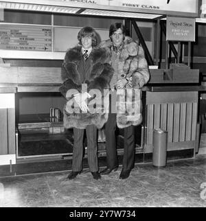 Robin (links) und Barry Gibb von der Popgruppe Bee Gees warten gut in Pelz eingewickelt auf ihren Flug am Flughafen London Heathrow. Sie gehen zurück nach Hause, mit der glücklichen Nachricht, dass ihr neuester Rekord „World“ immer noch in den Top-Ten-Charts steht. Eine Sache, die sie nicht brauchen, wenn sie am Ziel ankommen, ist ein Pelzmantel. Die beiden Mitglieder der fünf-Mann-Gruppe reisen nach Australien, derzeit mitten in einem heißen Sommer. 18. Dezember 1967 Stockfoto