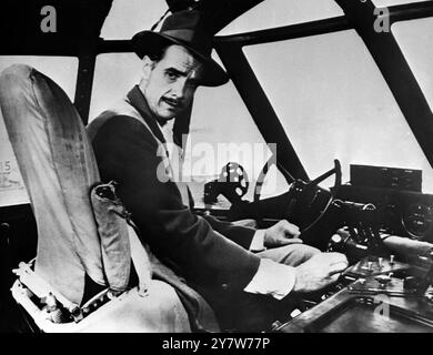 Der Flugzeugbauer Howard Hughes sah auf dem Pilotensitz hoch oben in der Nase des riesigen Flugbootes aus Sperrholz, das er auf Terminal Island im Hafen von Los Angeles, USA, baute. Das große Schiff ist nun fast fertig, um Taxifahrten auf den Hafengewässern durchzuführen.3. November 1947 Stockfoto