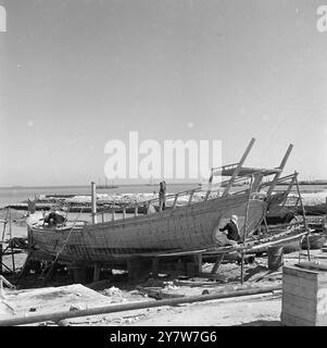 Katar - 1954 Eine Dau in Reparatur an der Hafenpromenade von Doha. Stockfoto