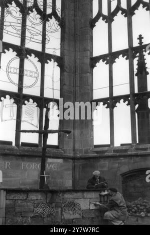 Coventry Cathedral Ancient und ModernWorkmen beschäftigten sich, um den Zustand der Reparatur in den bombardierten Ruinen der alten Kathedrale beizubehalten. Diese Ansicht befindet sich im Heiligtum und zeigt den Altar aus Ruinen und das Kreuz aus zwei verkohlten Balken. September 1953 Stockfoto