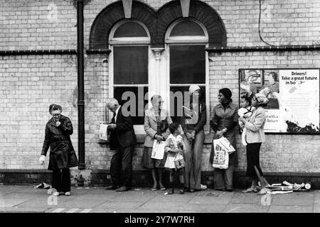 Eine Gruppe schwarzer Frauen und ihre Kinder warten mit einem älteren Paar, an der Westbourne Park Underground Station, Notting Hill, London, England.1970s Stockfoto