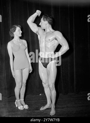 Die Jury für den diesjährigen Mr Universe Contest fand heute im Royal Hotel in London statt. Der Wettbewerb, bei dem die beste entwickelte Körperschaft der Welt ausgetragen wird, wird von der National Amateur Body Building Association organisiert. Foto-Shows: Miss Norma Tinker, 18, von Grimsby wirft einen Blick auf Arnold Dyson aus Liverpool. Sie nimmt am Miss Britain-Wettbewerb Teil. 1. September 1951 Stockfoto