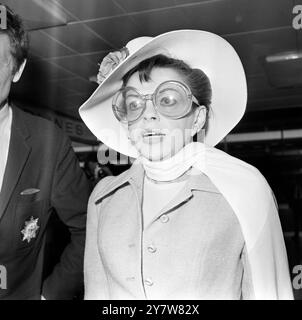 " IRGENDWO ÜBER DEM REGENBOGEN "... Amerikas eigener Sänger JUDY GARLAND , die als Teenager-Star in dem Film, in dem sie " irgendwo über dem Regenbogen " sang, weltberühmt wurde, wird dargestellt, als sie gestern Abend den Londoner Flughafen Heathrow auf einer Geschäftsreise nach New York verließ . Sie wurde von ihrem Mann Mickey Deans begleitet . Für die Reise trug Judy ein schickes Reiseoutfit , eine große Hornbrille und einen fließenden Schal . 1969 2019 neue Filmstars Renee Zellweger als Judy Stockfoto