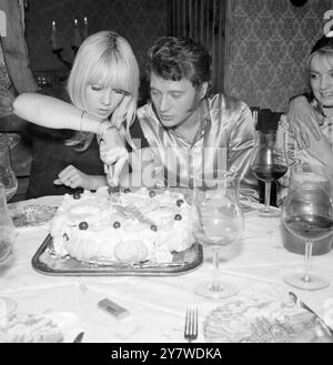 Paris : der französische Popsänger Johnny Hallyday und Sylvie Vartan sangen ein Paar , das auf einer privaten Party zum zweiten Jahrestag ihrer Ehe Kuchen schneidet . 15. April 1967 Stockfoto