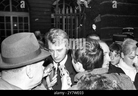 Eine riesige Menge von Fans und Nachrichtensprechern umzingelt den französischen Popsänger Johnny Hallyday (Mitte), als er am 24. November 1967 im Pariser Gerichtsgebäude ankam, um wegen Verkehrsdelikten zu erscheinen. Stockfoto