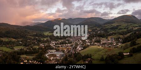 Die Panoramalandschaft der Stadt Ambleside im Lake District mit Loughrigg fiel zurück und Sturmwolken mit Regen bei Sonnenaufgang Stockfoto
