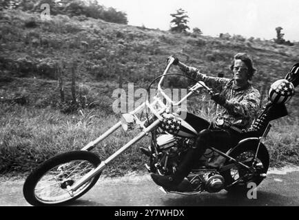 Schauspieler Peter Fonda, der ein komisches Motorrad fährt, das als „Chopper“-Bike bekannt ist, mit einer genarkten Front. In einer Szene aus dem Film „Easy Rider“ 1969 Stockfoto