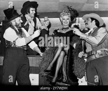 Der US-amerikanische Filmstar Betty Grable wird von Peter Honri , Blayne Barrington und Ray Chiarella am Alhambra Theatre in die Brille gehoben . Betty spielt " Belle Star " in der Produktion " The Piecefull Palace " . Das Musical im Palace Theatre in London. 7. April 1969 Stockfoto