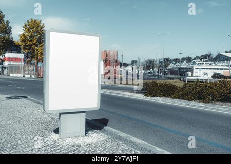 Leeres urbanes Reklametafeln in einer modernen Stadtstraße. Leere Werbefläche in einem eleganten Metallrahmen, stehend auf einem Kopfsteinpflaster mit Straße, tr Stockfoto