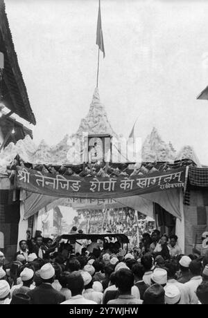 Durch das Triumphtor kommen die everest-Eroberer. Mitglieder der britischen Expedition, die den Everest eroberte, wurden bei ihrer Rückkehr nach Kathmandu triumphierend begrüßt. Das Bild zeigt Colonel John Hunt und Edmund Hillary, die durch das Triumphtor auf der Spitze reiten , das ein Porträt von Nepals eigenem Mitglied der Expedition , Sherpa Tensing , darstellt . 24. Juni 1953 Stockfoto