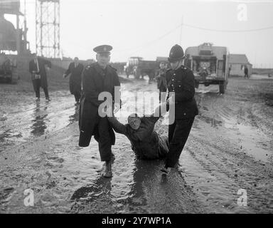 Zwei Polizisten entfernen will Warren aus Oxford gewaltsam vom Standort einer geheimen US-Raketenbasis, nachdem er sich weigerte, von sich aus zu gehen. Er und etwa fünfzig Mitglieder des Direct Action Committee Against Nuclear war drangen am 6. Dezember 1958 in Swaffham in Norfolk ein Stockfoto