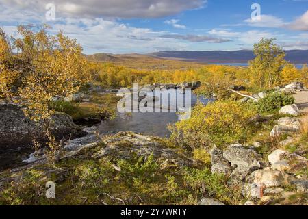 Herbstbach in der Nähe eines Wasserfalls am Tsahkaljoki-Fluss mit Blick auf den Kilpisjrävi-See in Kilpisjärvi, Finnland Stockfoto