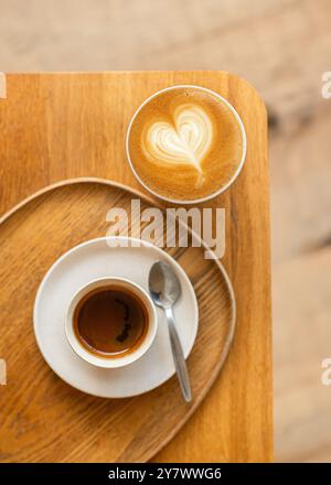 Tasse Cappuccino mit wunderschöner Creme Latte Art auf einem minimalistischen Coffee Shop Tisch. Minimalistischer Stil. Draufsicht. Stockfoto