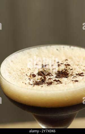 Köstlicher Espresso-Martini mit Kaffeebohnen im Glas auf verschwommenem Hintergrund, Nahaufnahme Stockfoto