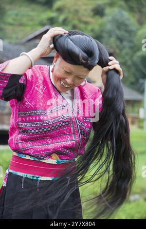 Langen Haaren Yao Frau wickeln ihr Haar, eine Tradition gehalten, indem die roten Yao in der Nähe von Guilin, China Stockfoto