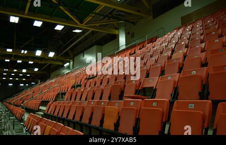 Orangefarbene Sitzplätze in einer Sportarena, die als Zuschauer für verschiedene sportliche Veranstaltungen und Wettbewerbe eingerichtet werden. Stockfoto