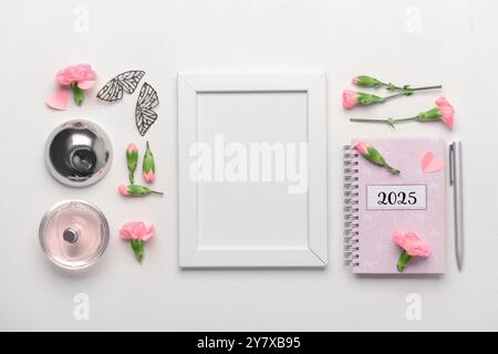 Fotorahmen mit Notizbuch und schönen Blumen auf weißem Hintergrund Stockfoto